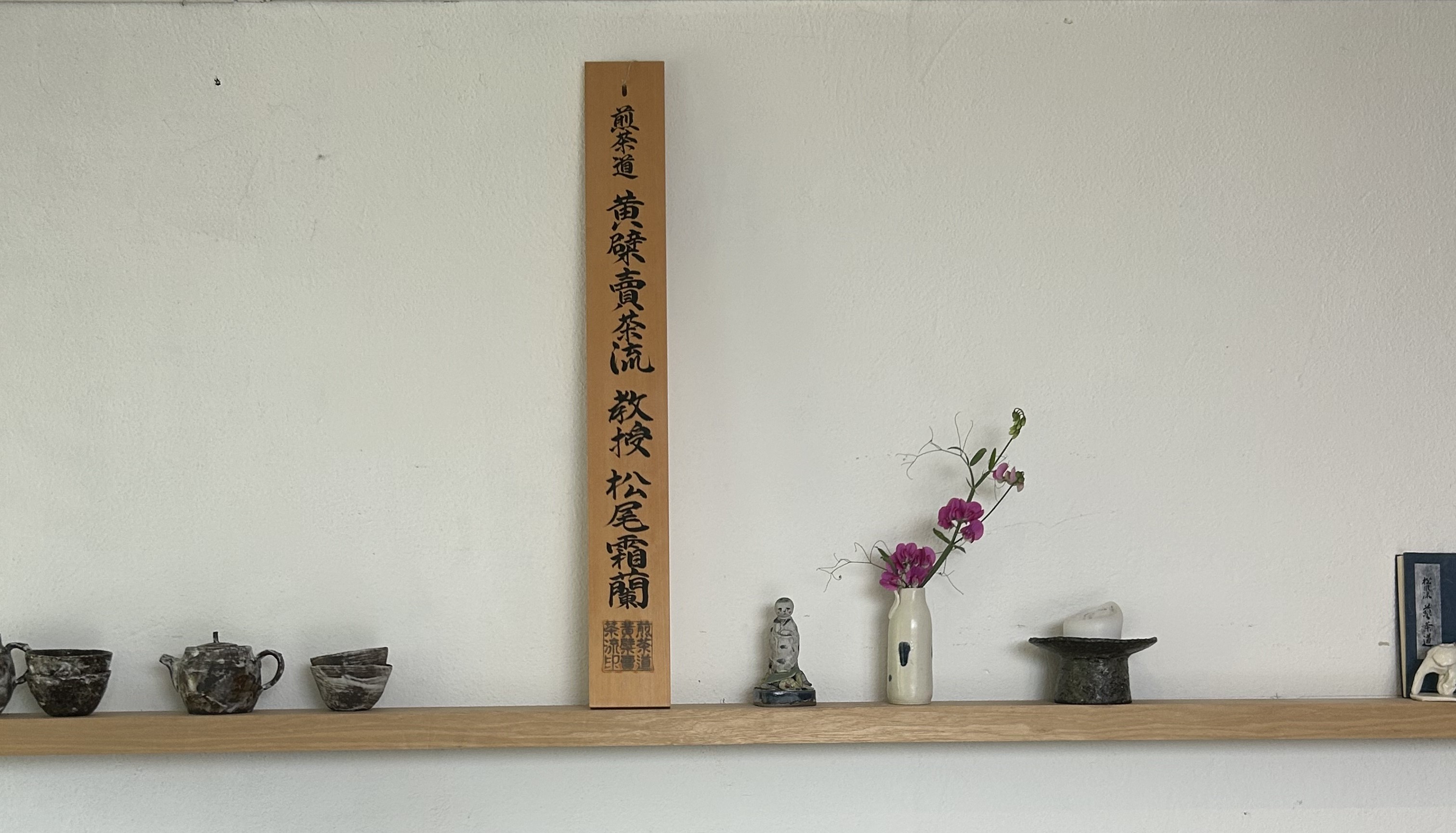 Haruka's wooden teaching-license plaque from the Ōbaku Baisa-ryū school of sencha, shown here on a shelf alongside her ceramics.